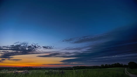 Timelapse-shot-of-green-grasslands-on-both-sides-of-a-narrow-gravel-path-in-Countryside-duing-evening-time