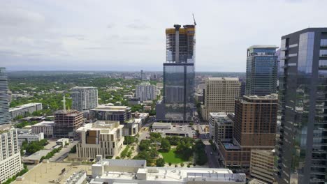 Aerial-view-towards-a-new-skyscraper-under-construction,-in-sunny-Austin,-USA---Sixth-and-Guadalupe