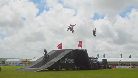 El-Equipo-De-Exhibición-De-Acrobacias-De-Motocross-De-Estilo-Libre-Realiza-Trucos-Volando-En-El-Aire-En-El-Evento-De-Gran-Salto-En-El-Show-De-Royal-Cornwall,-Reino-Unido---Toma-Amplia-En-Cámara-Lenta