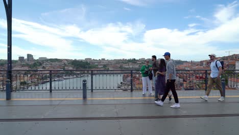 Joven-Pareja-Asiática-Caminando-Por-El-Puente-Dom-Luís-I-Con-El-Panorama-De-La-Ciudad-De-Porto-En-Segundo-Plano