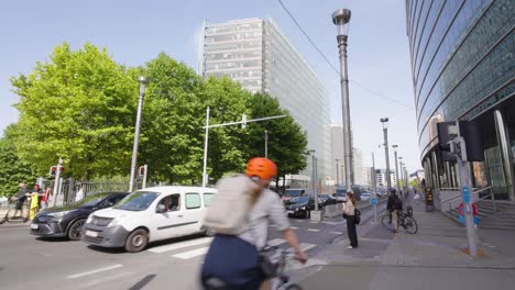 People-on-bikes,-electric-scooters-and-by-foot-at-the-European-Quarter-in-Brussels,-Belgium