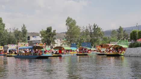 Blick-Auf-Bunte-Gondelboote,-Die-Touristen-Entlang-Der-Wasserstraßen-Von-Xochimilco-In-Richtung-Embarcadero-Nuevo-Nativitas-Transportieren