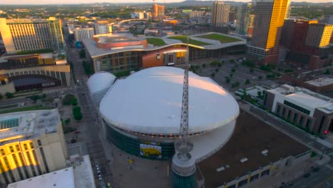 Aerial-view-in-front-the-Bridgestone-arena,-sunny-evening-in-Nashville,-USA---ascending,-tilt,-drone-shot