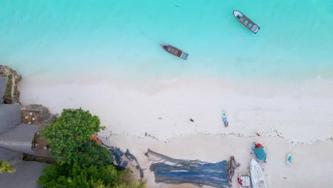 Nungwi-Beach,-Zanzibar---Tanzania---June-18,-2022---Boats-on-the-Indian-ocean-on-a-sunny-cloudy-day-during-sunrise