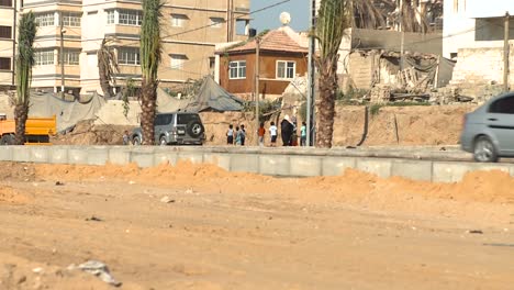 A-family-walk-down-the-sidewalk-of-a-busy-main-road-in-Gaza,-Palestine