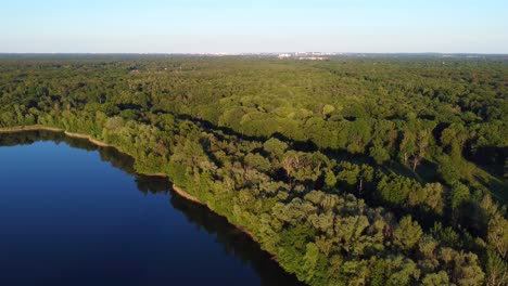 On-the-horizon-a-large-city-forest-by-the-lake-Breathtaking-aerial-view-flight-panorama-overview-drone-footage
in-Brieselang-Germany-Europe-at-summer-2022
