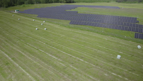 Fenced-Solar-Farm-Nearby-Agricultural-Field,-Aerial-Dolly-out-View