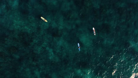 descending-birds-eye-view-of-surfers-waiting-for-waves