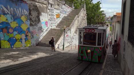 El-Tranvía-Remodelado-Pintado-Con-Graffiti-En-Lisboa-Yendo-A-La-Parte-Baja-De-Lisboa-Con-Gente-Tomándole-Fotos