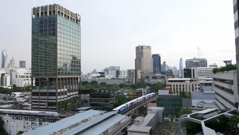 Cityscape-view-of-BTS-trains-passing-near-in-front-of-Asia-Hotel-in-Bangkok,-Thailand,-Southeast-Asia
