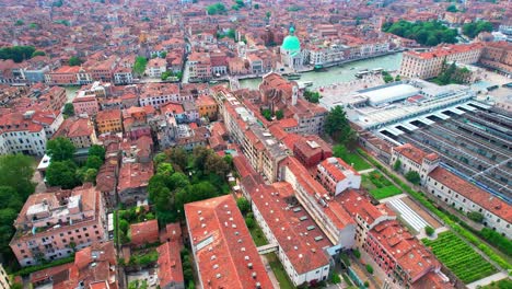 Aerial-View-Of-Santa-Lucia-Train-Station-With-Pan-Left-View-Of-Orange-Rooftops-In-Venice-With-Tilt-Up-View-Of-Cityscape