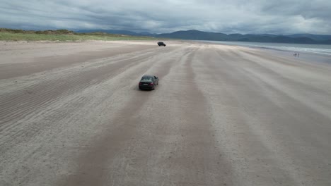 Car-driving-on-Inch-beach-Dingle-peninsula-Ireland-drone-aerial-view
