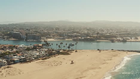 Beautiful-aerial-drone-of-California-coastal-beach-with-boats-in-the-harbor---Graded