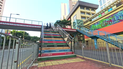 Zeitraffer-Von-Menschen,-Die-Die-Farbenfrohe-Olympia-Fußgängerbrücke-In-Causeway,-Hongkong,-Hinuntergehen