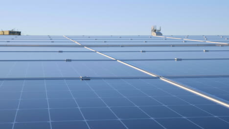 Nahaufnahme-Der-Solarpanel-Technologie-In-Reihen-Auf-Dem-Dach-Mit-Blauer-Himmelsreflexion,-4K-Zeitlupe
