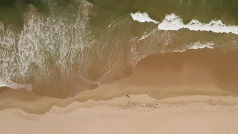 Blick-Aus-Der-Vogelperspektive-Auf-Wellen,-Die-An-Einem-Schönen-Und-Ruhigen-Sandstrand-Ankommen