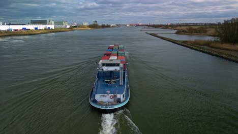 Luftaufnahme,-Die-Dem-Großen-Frachtschiff-Mit-Containern-Durch-Die-Kanäle-Von-Zwijndrecht,-Niederlande,-Folgt