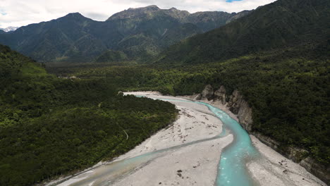 Turquoise-water-of-Waiho-river-flowing-from-Franz-Jozeph-glacier,-New-Zealand,-aerial-view