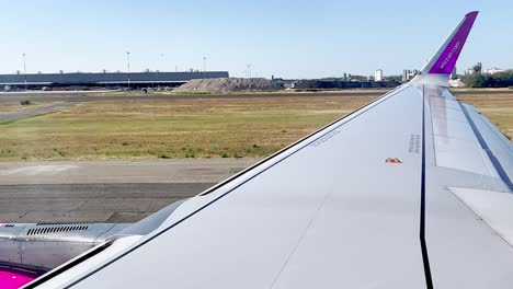 Wizzair-jet-airplane-wing-landing-in-Rome-Fiumicino-airport-in-Italy