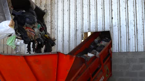 Der-Eimer-Eines-Bulldozers-Wirft-Den-Abfall-In-Den-Trichter-Eines-Förderbandes-In-Einer-Abfallverarbeitungsanlage