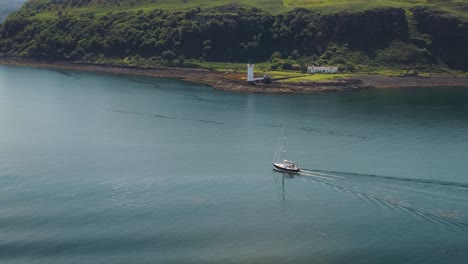 Luftdrohnenaufnahme-Eines-Bootes,-Das-Am-Leuchtturm-Von-Tobermory-Und-Der-Küste-Der-Isle-Of-Mull-Vorbeifährt