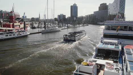 Tourist-boat-passing-by-at-Hamburg-Landungsbrücken-with-Elbphilharmonie