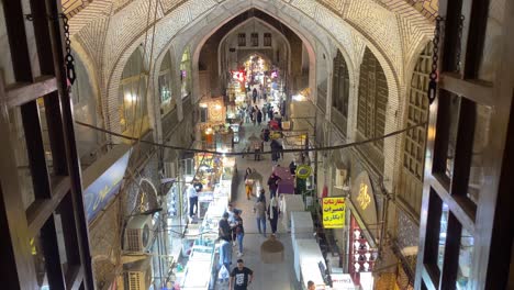 Wood-working-frame-window-door-on-top-hall-of-the-Esfahan-city-bazaar-traditional-mall-brick-arch-store-people-shop-walking-in-old-cultural-attraction-scenic-wide-view-of-Persian-economy-business