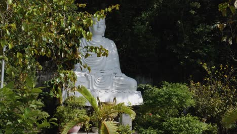 marble-Buddha-statue,-surrounded-by-lush-greenery-located-at-Marble-Mountains-in-Da-Nang,-Vietnam