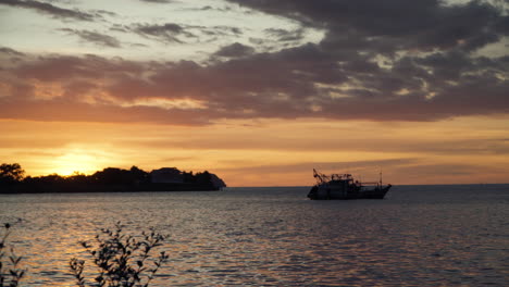 Silhouette-Eines-Angedockten-Fischerbootes-Mit-Atemberaubendem-Goldenem-Sonnenuntergang-Im-Hintergrund-An-Der-Küste-Von-Kota-Kinabalu