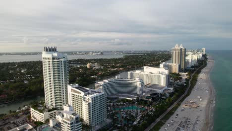 Miami-Beach-in-the-evening,-drone-shot-of-the-beachfront-with-hotels-and-resorts