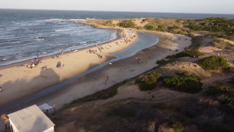 People-sunbathe-on-Playa-Grande-beach-on-sunny-day,-Punta-del-Diablo-in-Uruguay
