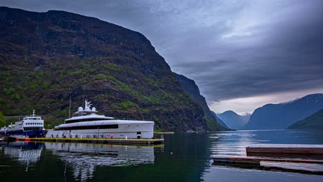 Mega-yacht-moored-in-port-of-Flam-town-in-Norway-fjord,-fusion-time-lapse