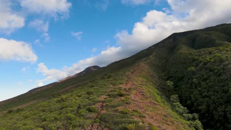 FPV-aerial-view-climbing-the-mountains-of-Molokai,-exploring-waterfalls-and-hidden-trails-in-this-tropical-paradise