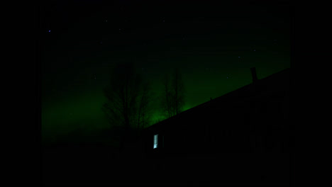 Northern-Lights-Shine-Brightly-Behind-Finnish-House,-Time-Lapse