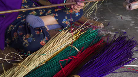 Woman-making-a-carpet-from-colorful-straws