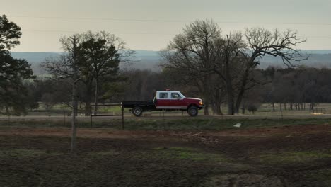 truck-side-view-driving-through-the-country-past-farms-and-trees-during-the-late-afternoon-in-slow-motion