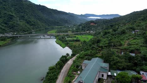 Stunning,-Establishing-Birdseye-view-of-vast-river-and-modern-bridge-between-lush-jungles-and-hills-in-the-Island-of-Catanduanes