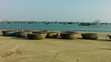 Dolly-shot-past-a-man-sorting-out-sandbags-with-boats-on-the-shore-and-floating-in-the-bay-of-Da-Nang