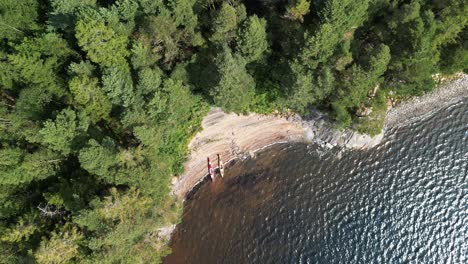 View-of-kayaks-on-a-summer-beach,-Sweden,-Top-Down-Aerial