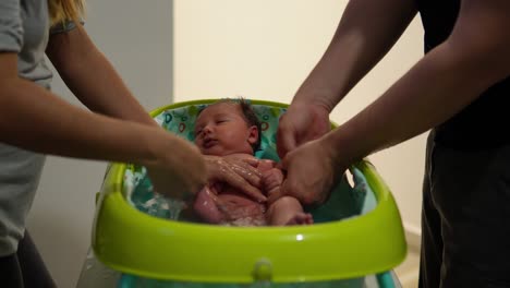 Wunderschönes-Baby-Und-Kuschelig,-Wie-Es-Von-Seinen-Eltern-In-Einer-Badewanne-Gebadet-Wird