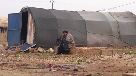 old-Syrian-widow-lady-setting-alone-by-refugee-camp-tent