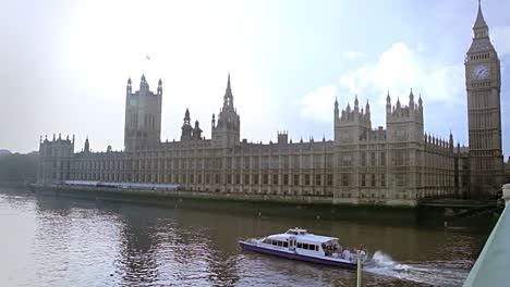 Parlamentsgebäude-Mit-Einem-Langen-Touristenboot,-Das-An-Einem-Sehr-Sonnigen-Tag-In-London,-England,-Durch-Die-Themse-Fährt