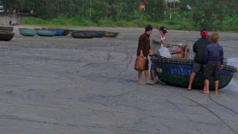 Kamerafahrt-Von-Menschen,-Die-Vorräte-In-Ein-Kleines-Traditionelles-Fischerboot-In-Da-Nang-Tragen