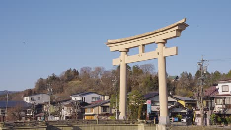 Japanese-Tonbi-Kite-Bird-Flying-Past-Giant-Torii-at-Takayama,-Gifu