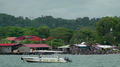 Pueblo-De-Agua-Y-Barco-Turístico-En-El-área-De-La-Bahía-Del-Distrito-De-Kampung-Tanjung-Aru-Lama,-Casas-De-Inmigrantes-De-Bajos-Ingresos-En-Sabah,-Kota-Kinabalu