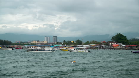 Kampung-Tanjung-Aru-Lama-Marina-Bay-Mit-Vielen-Schwimmenden-Festgemachten-Booten-In-Der-Nähe-Von-Häusern-Armer-Menschen,-Die-Auf-Dem-Wasser-In-Kota-Kinabalu,-Malaysia,-Gebaut-Wurden