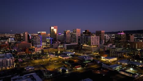 Aerial-view-towards-the-west-skyline-of-Phoenix-city,-colorful-dusk-in-Arizona,-USA