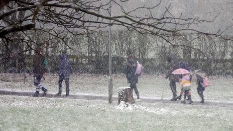 Gente-Caminando-Niños-A-La-Escuela-En-Ventisca-Nieve-Clima-Frío-En-Condiciones-De-Tormenta-De-Invierno-Ventoso-Reino-Unido