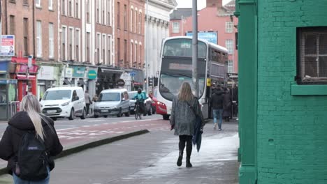 Día-De-Trabajo-En-La-Ciudad-De-Corcho-De-La-Calle-Washington-Con-Peatones-Femeninos,-Repartidor-En-Bicicleta-Y-Autobús-En-Una-Estación-De-Autobuses