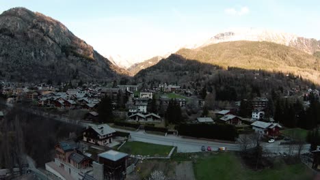 FPV-drone-aerial-in-alpine-mountain-resort-Courmayeur,-Aosta-Valley,-Italy-at-foot-of-Alps-Mont-Blanc-Monte-Bianco,-flying-over-houses-and-forest